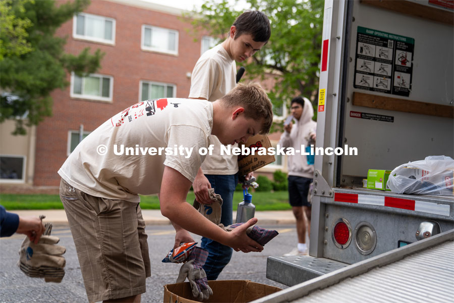 Big Event student volunteers pick out sets of working gloves for the task ahead of them. May 4, 2024. Photo by Kirk Rangel for University Communication.